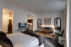 a bedroom with a large bed and a living room at Suite Prado in Madrid