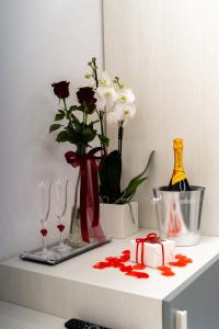 a shelf with wine glasses and flowers on it at Cattleya Rooms in Sestu