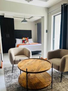 a living room with a table and two chairs and a bed at Xitshavani Lodge in Phalaborwa