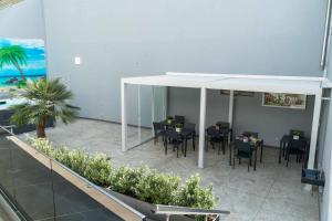 a dining room with tables and chairs under an umbrella at Cattleya Rooms in Sestu
