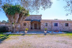 a stone house with a tree in front of it at Casa Ailen in Islas Baleares