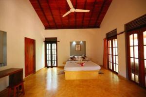 a bedroom with a bed and a ceiling fan at Mangrove Beach Chalets in Tangalle