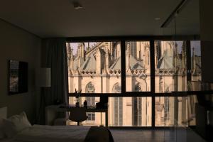 a bedroom with a view of a building through a window at Hotel Am Domplatz - Adult Only in Linz +36 photos