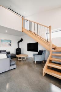a living room with a staircase and a couch at Connewarre Farm Stay - Sleeps 10 - Acreage By HostyCo in Connewarre