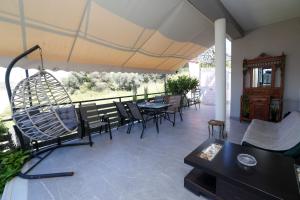 a patio with tables and chairs and a swing at Villa Laurela in Salamina