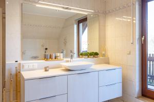 a white bathroom with a sink and a mirror at Haus Altburgstädtel in Dresden +34 photos