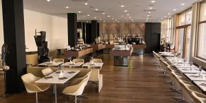 a restaurant with tables and chairs and a bar at Hotel Am Domplatz - Adult Only in Linz