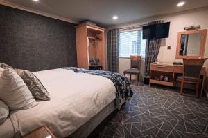 a hotel room with a bed and a desk at Anchorage Inn in Portstewart