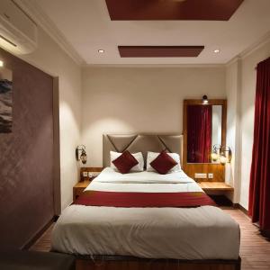a bedroom with a large bed with red curtains at Sienna Suites in Navi Mumbai +71 photos