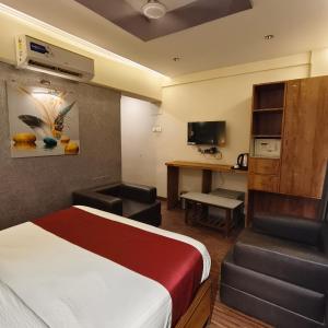 a hotel room with a bed and a desk at Sienna Suites in Navi Mumbai
