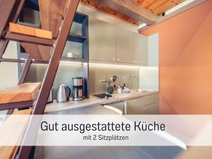 a kitchen with a spiral staircase in a loft apartment at Isetta Wettelsteck - Mini Ferienhaus in Kyritz, einer charmanten Stadt im Herzen von Brandenburg in Kyritz +26 photos