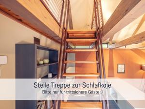 a loft bed in a house with a ladder at Isetta Wettelsteck - Mini Ferienhaus in Kyritz, einer charmanten Stadt im Herzen von Brandenburg in Kyritz