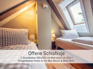 a attic bedroom with two beds and a window at Isetta Wettelsteck - Mini Ferienhaus in Kyritz, einer charmanten Stadt im Herzen von Brandenburg in Kyritz