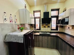 a kitchen with wooden cabinets and a table with flowers on it at Nasadra villa in Jaipur