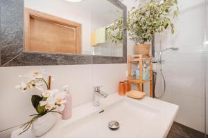 a white bathroom with a sink and a mirror at Landhaus Gerstgraser in Rauris
