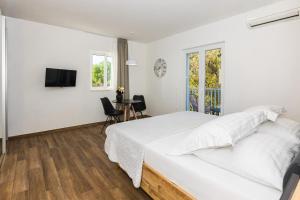 a white bedroom with a bed and a television at Marojica Apartments 2 in Cavtat +31 photos