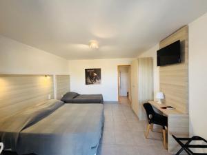 a hotel room with a large bed and a desk at Clamador in Saintes-Maries-de-la-Mer