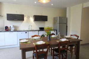 a kitchen with a wooden table with chairs and a kitchen with a tableablish at Graine in Dommartin-le-Franc