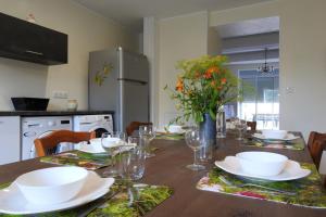 a kitchen with a wooden table with plates and glasses at Graine in Dommartin-le-Franc +10 photos
