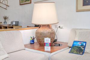 a lamp sitting on a table next to two chairs at Marana Orizzonte in Santa Marinella +19 photos