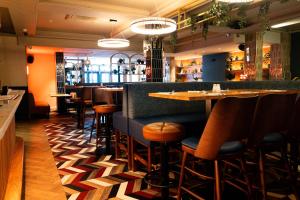 a restaurant with a bar with wooden stools at Anchorage Inn in Portstewart