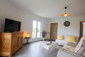 a living room with a couch and a flat screen tv at Le repere in Tocane-Saint-Apre
