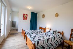 a bedroom with two beds and a room with a tv at Le repere in Tocane-Saint-Apre