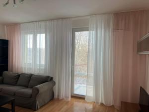 a living room with a couch and a large window at Iris Apartment in Dunajská Streda