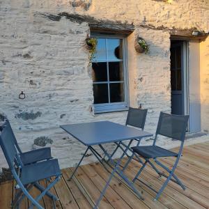 a blue table and four chairs on a deck at B&B suite de charme in Guipry-Messac
