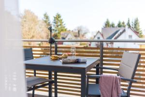 a table and two chairs on a balcony at Am Park 27 in Prerow +8 photos