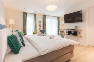 a bedroom with a large bed with a tv on the wall at Am Park 27 in Prerow