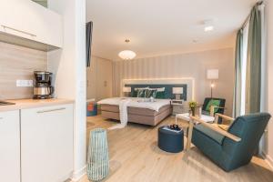 a bedroom with a bed and a couch and a chair at Am Park 27 in Prerow