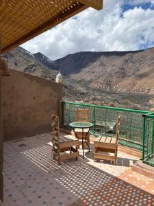 a patio with two chairs and a table with a view at La Perle de Neige in Imlil