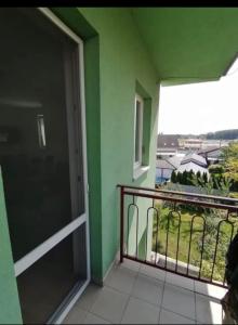 a balcony with a door and a green wall at Iris Apartment in Dunajská Streda
