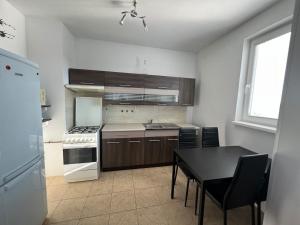 a kitchen with a table and a stove top oven at Iris Apartment in Dunajská Streda