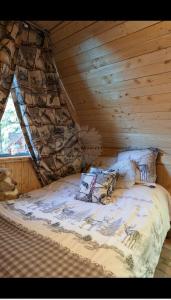 a bed in a room with a wooden ceiling at la marmotte in Granges-Aumontzey