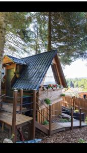 a small house with a black roof on a deck at la marmotte in Granges-Aumontzey