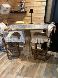 a wooden table with a tree stump under it at la marmotte in Granges-Aumontzey