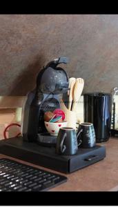 a coffee maker sitting on top of a counter with cups at la marmotte in Granges-Aumontzey