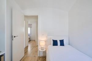 a bedroom with a white bed with a blue pillow at CASA CALMA Blanes in Blanes +48 photos