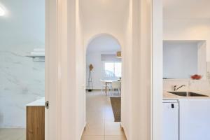 an archway in a kitchen leading to a dining room at CASA CALMA Blanes in Blanes