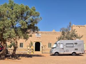 a white van parked in front of a building at Auberge camping la tradition in Merzouga