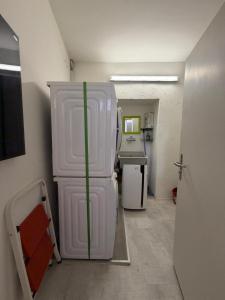 a small kitchen with a white refrigerator in a room at Lakeview Hideaway - Brissago in Brissago