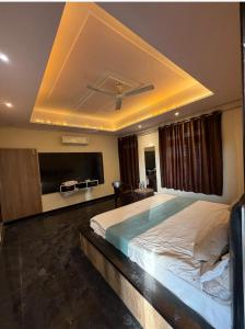 a bedroom with a large bed with a ceiling at GooD TIME HOME STAY in Jāmb
