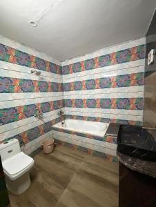 a bathroom with a toilet and a bath tub at GooD TIME HOME STAY in Jāmb