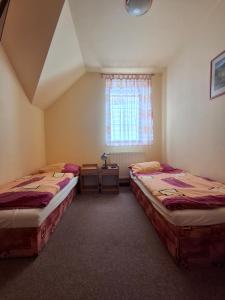 two beds in a room with a window at Horská bouda Aldrov in Vítkovice