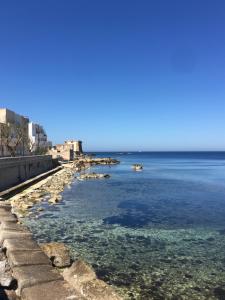 a view of the ocean with rocks in the water at La CASA DEL SOLE in Paceco