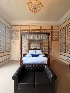 a bedroom with a bed with a black leather couch at The Old Lodge in Malton