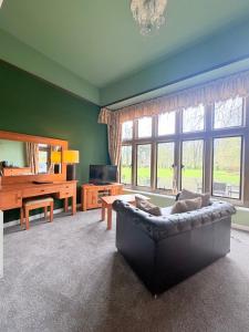 a living room with a couch and a large window at The Old Lodge in Malton