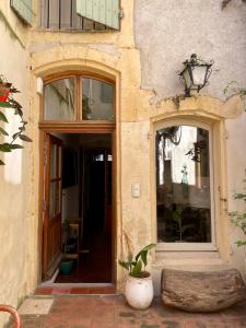 an entry to a building with two windows and a door at Le Patio d'Arles in Arles